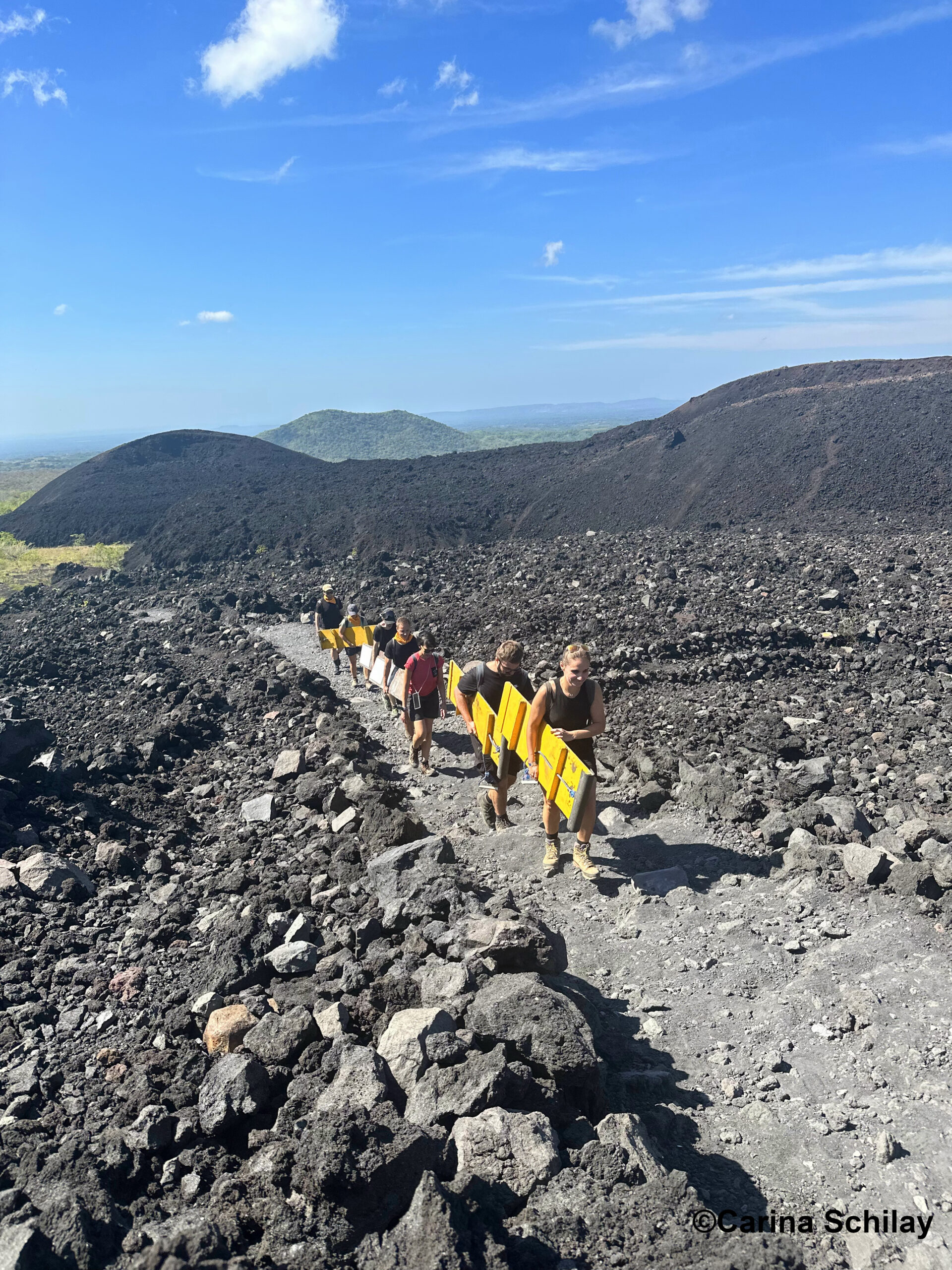 Abenteuerlustige erklimmen den Cerro Negro in Nicaragua, bereit für eine rasante Sandboarding-Session unter der strahlenden Sonne.