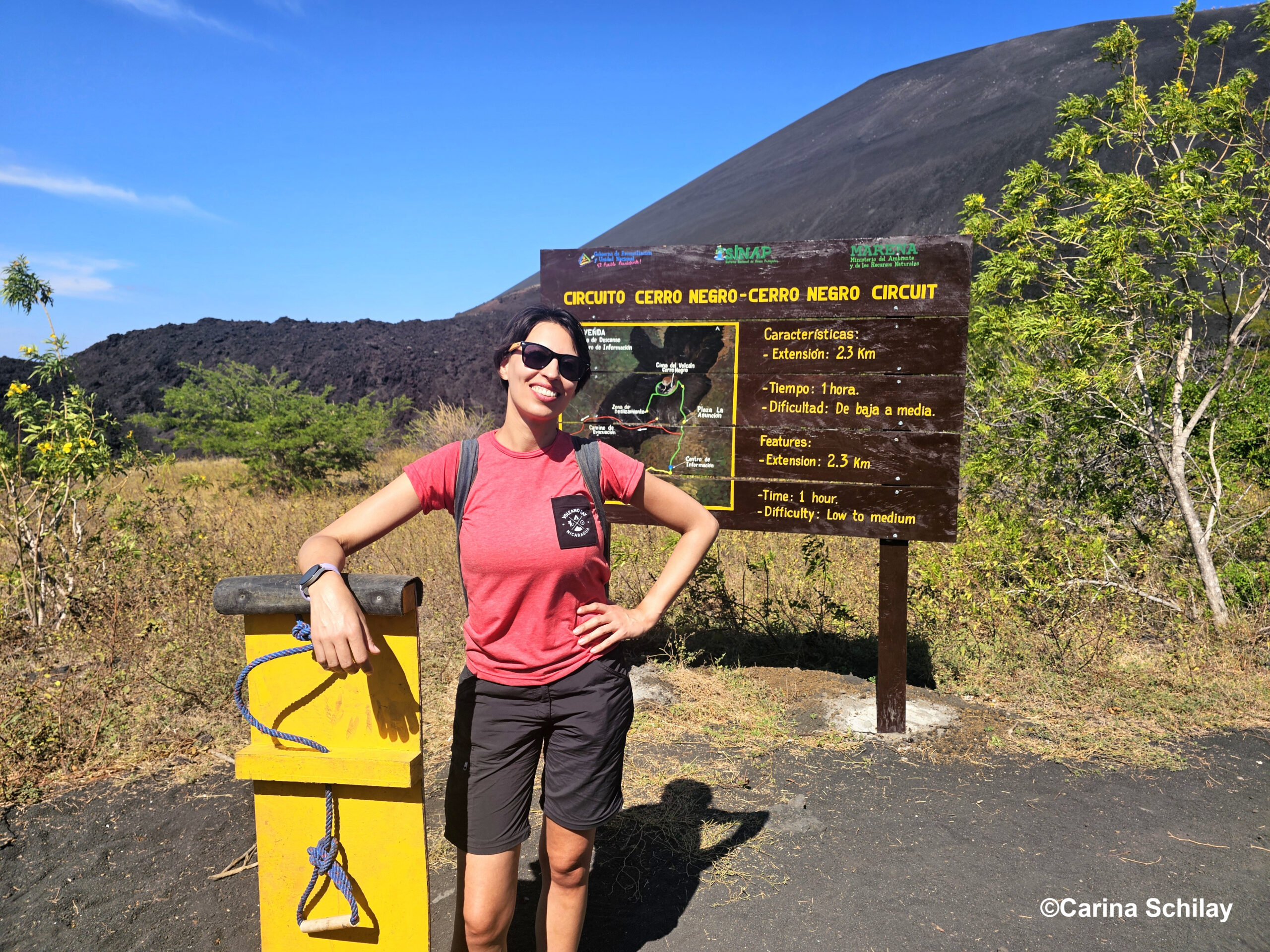 Abenteuerlustige Person lehnt am Einstiegspunkt des Cerro Negro, bereit zum Sandboarding.