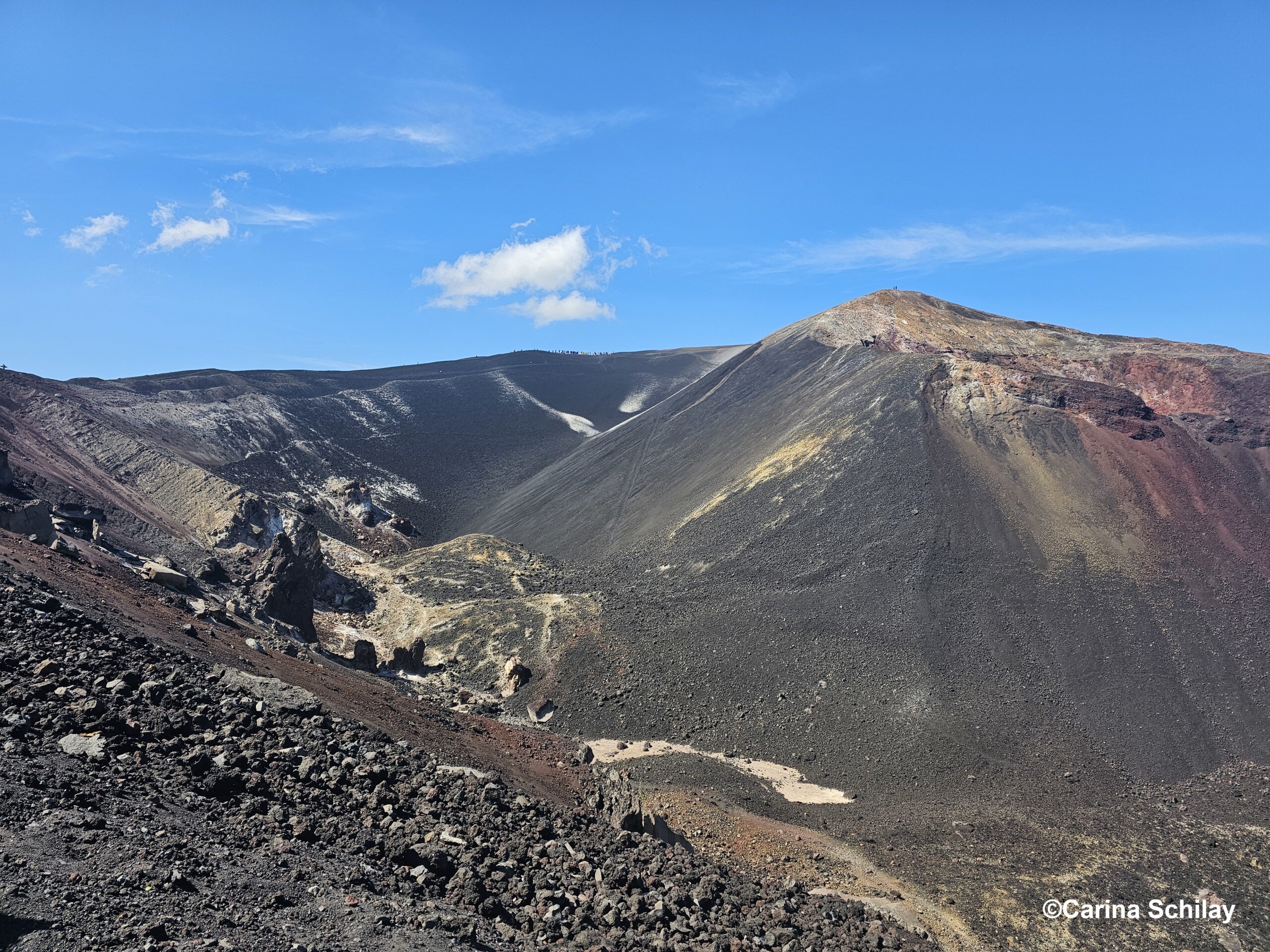 Sandboard-Abenteuer wartet auf dem schwarzen Aschehang des Cerro Negro in Nicaragua unter einem strahlend blauen Himmel.