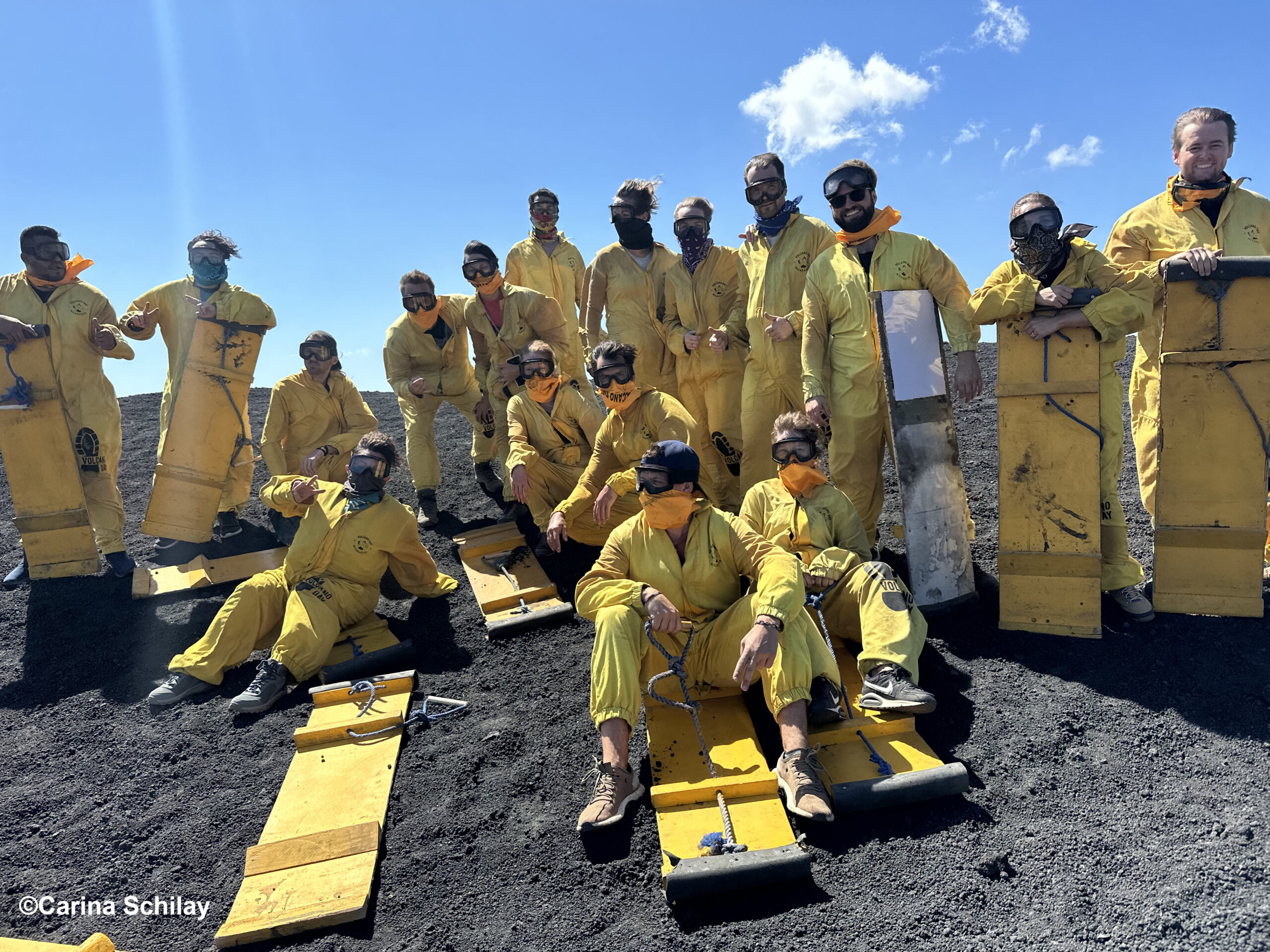 Abenteuerlustige Sandboarder in gelben Schutzanzügen bereiten sich auf die rasante Abfahrt am Cerro Negro in Nicaragua vor