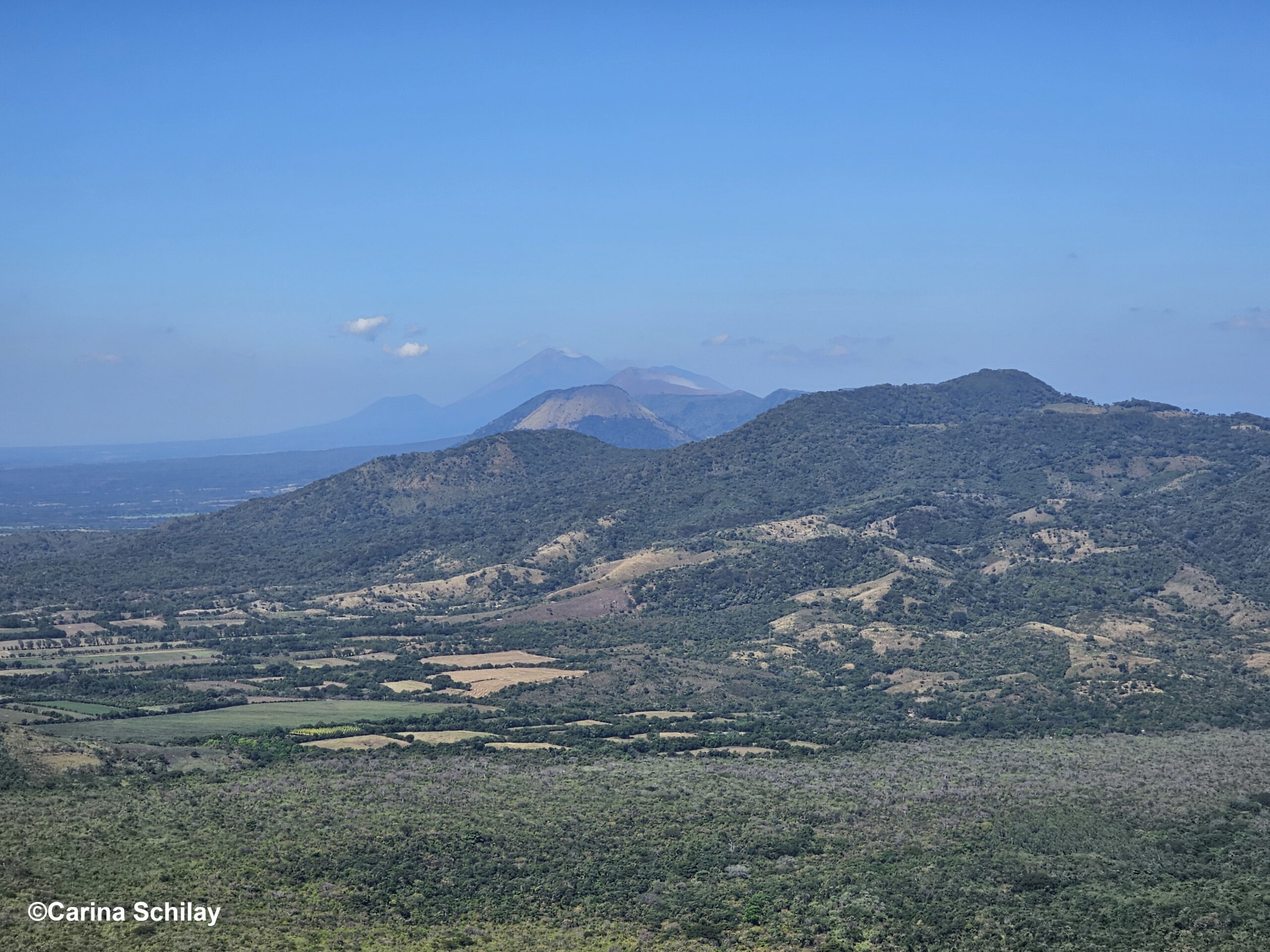 Blick vom Cerro Negro auf eine Kette von Vulkanen unter einem weiten blauen Himmel – ein Paradies für Abenteurer und Naturfreunde