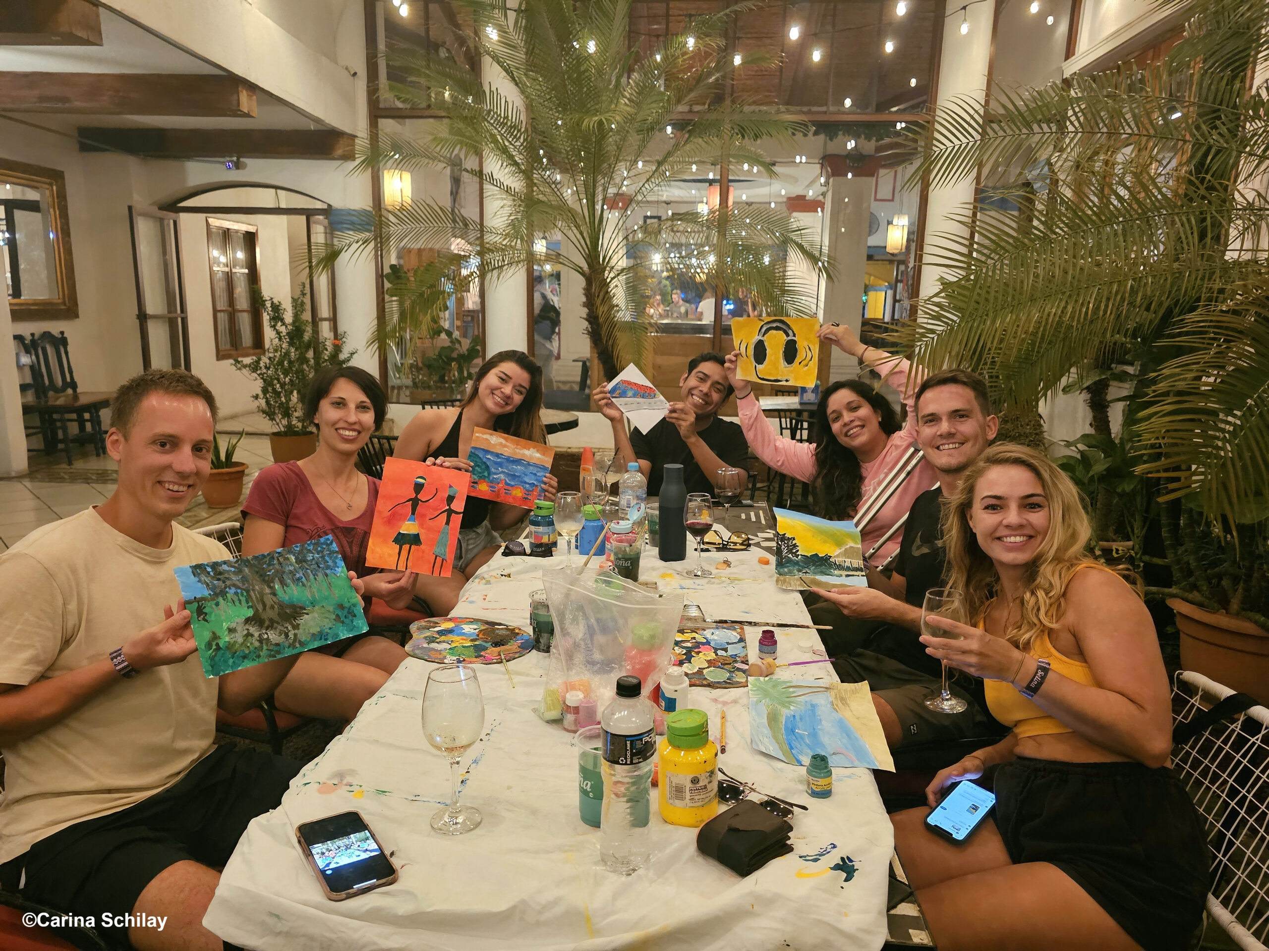 Kreative Seelen beim Wine and Paint Workshop in Granada – Farbenfrohe Kunstwerke treffen auf tropisches Ambiente.